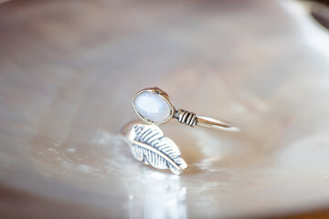 Elegant silver ring with moon gemstone on rocky background