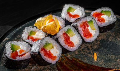 sushi roll with salmon, avocado, rice in plate