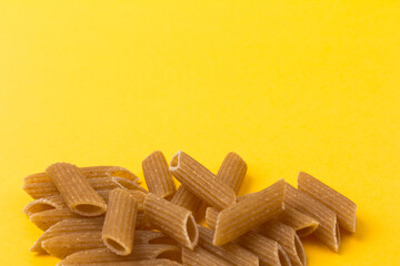 Pasta from hard wheat. Italian pasta on yellow background,  place for text.