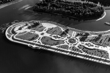 an amusement and recreation park with fountains on a peninsula next to a large river filmed from a...