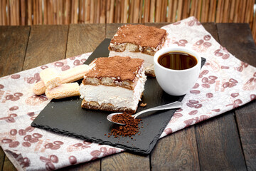 Tiramisu and cup of coffee on table, delicious dessert