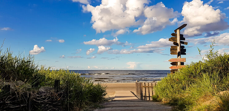 View of Jurmala coast with sea and pillar with direction signs.