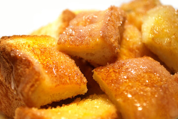 Butter baked bread topped with condensed milk sprinkled with sugar.