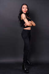 Young beautiful Asian transgender woman against black background