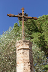 Obraz premium Stone pedestal with a crucifix in an old garden, Valencia, Spain.