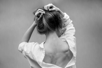 Fototapeta premium Woman's back. Hands on the head. Black and white photo