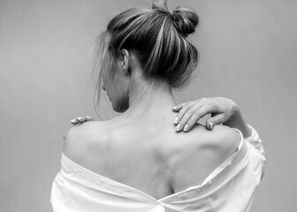 Woman's back. Hands on the shoulders and neck. Black and white photo