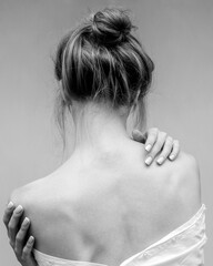Woman's back. Hands on the shoulders and neck. Black and white photo