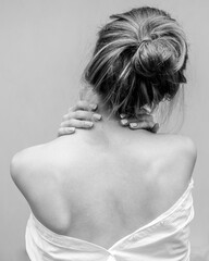 Woman's back. Hands on the shoulders. Black and white photo