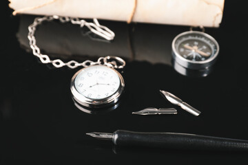 Fountain pen with pocket clock on dark background