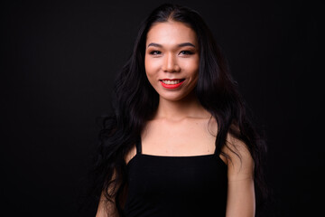 Young beautiful Asian transgender woman against black background