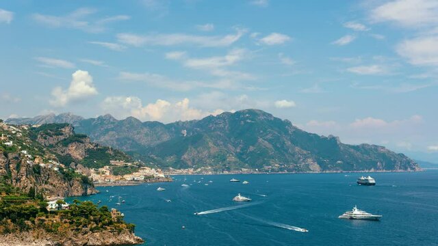 Time lapse view from Conca dei Marini on Amalfi bay, Luxury boats traffic, ocean liner, fishing boats, tourist season. watercraft. Mountains and houses, buildings. Summer day in vacation. Italy