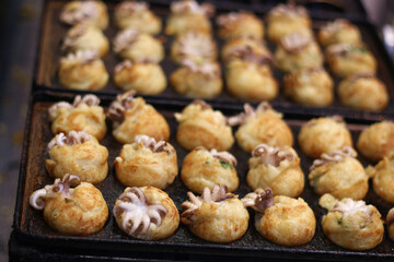 Close up of a pan of cooking takoyaki (octopus balls), Osaka, Japan, Asia, soft focus