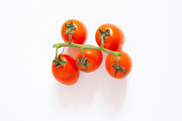 Red cherry tomatoes on a branch, isolated on a white background, top view