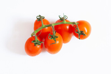 Ripe red cherry tomatoes on a branch, isolated on a white background, top view