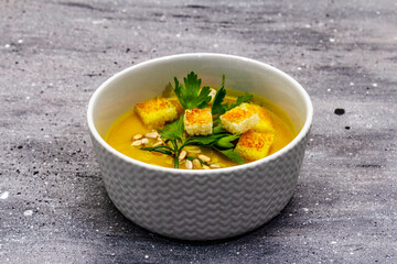 Yellow zucchini cream soup. Healthy vegan (vegetarian) food, crispy toast, sunflower seeds, fresh greens