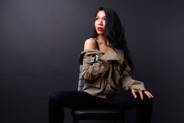 Obraz na płótnie Canvas Young beautiful Asian transgender woman against black background