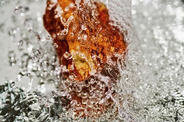 Orange stone under flowing clear water.