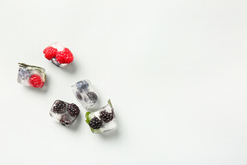 Ice with frozen berries on white background