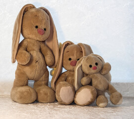 Family of bunnies on a white background. Plush rabbit toy.