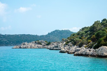 Obraz premium Seascape. View from the water to Islands in the Mediterranean sea. Wild unspoilt nature of Turkey. Stone cliffs and mountains covered with green bushes and trees. Summer landscape from pleasure boat