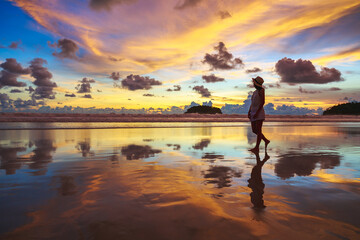 Traveler asian woman travel on Phuket beach in sunset Thailand