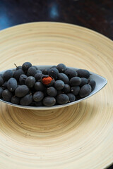 Velvet tamarind fruit ( Dialium cochinchinense) or buah keranji in a wooden bamboo plate background.