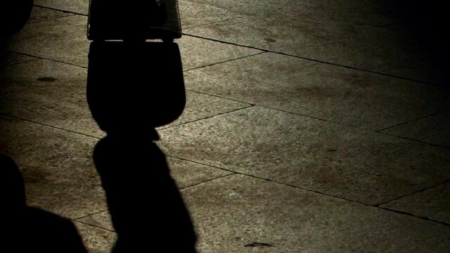 Skater appears from the shadows , throws his board and makes a trick on a backlight silhouette on the ground at the Macba plaza. in a super close up shoot.  Switch hellflip with power, grace and style