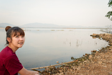 Asian female travelers has braces on are happy walking by the beach