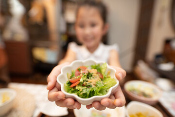 サラダを差し出す女の子