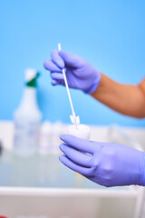 Doctor's hands in purple gloves collecting tests for testing