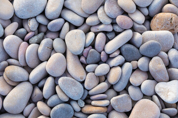 Fototapeta na wymiar Light blue and garnet smooth rocks on soft white rocks in outdoor natural landscape.