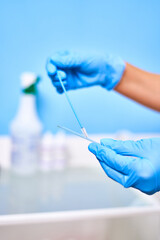 Doctor's hands in blue gloves collecting tests for testing