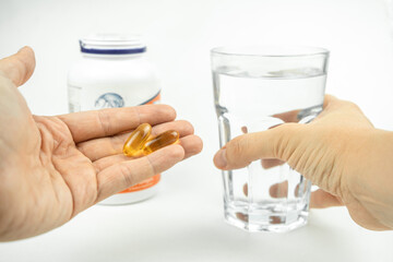 omega 3 fish oil big gel capsules and glass of water, healthcare, vitamins