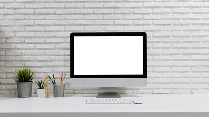 mockup computer with blank white screen, with workspace and office supplies on desk