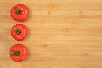 Fresh tomatoes on bamboo wooden background
