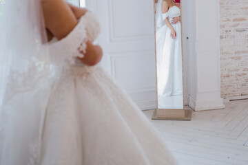 Fototapeta na wymiar bride in a wedding dress near the mirror