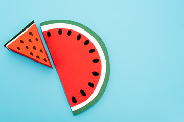 top view of paper watermelon slices on blue background