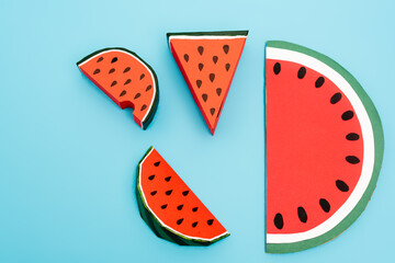 top view of paper watermelon slices on blue background