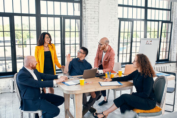 Beautiful business people are using gadgets, talking and smiling during the conference in office
