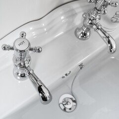 New and modern steel faucets with the ceramic sink in the bathroom