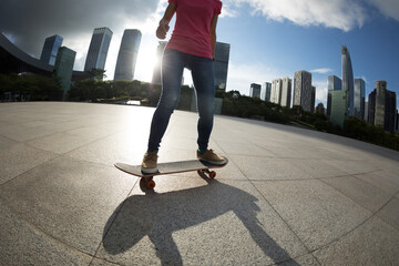 Asian woman skateboarder skateboarding in modern city