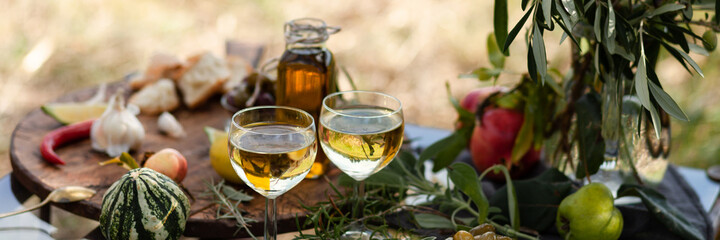 Romantic italian lunch outside for a couple: copper pan with delicious and spicy fried shrimps with herbs and garlic, wine, bread, olives. Bottle of olive oil. Luxury lifestyle, gourmet food. Banner