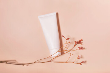 Blank cosmetic tube on a beige background