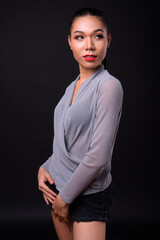 Young beautiful Asian transgender woman against black background