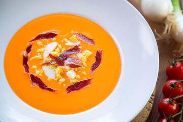 Traditional spanish Salmorejo. Cold tomato soup made with garlic, tomatoes, onion, bread and served with olive oil, iberico ham and boiled egg.