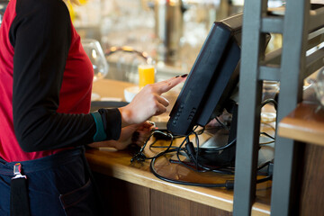 A waiter of a modern cafe or bar enters an order or payment via a tablet or a seekipper