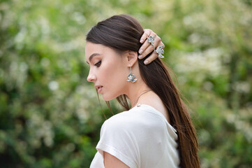 Fototapeta premium Close-up of the neck of a beautiful young blonde in a shirt with silver earrings