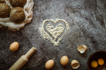 ingredients for baking rye buns, rolling pin, eggs, mixer, heart with flour