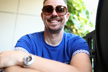 Man in sunglasses sits and smiles. Positive mood as a lifestyle concept